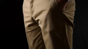 Um homem usando calças bege e uma camisa branca.
