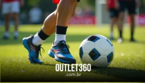 Close de uma pessoa com tênis azul e laranja em pé ao lado de uma bola de futebol em um campo gramado. O texto na parte inferior diz "OUTLET360.com.br.