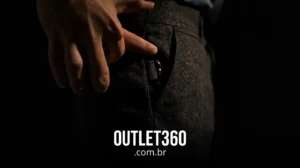 Uma mão alcança um pequeno objeto preso ao bolso de uma calça escura; o texto "OUTLET360 .com.br" aparece na parte inferior.