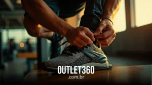 Close-up de uma pessoa amarrando os cadarços de um tênis esportivo cinza, com o texto "OUTLET360.com.br" exibido na parte inferior.